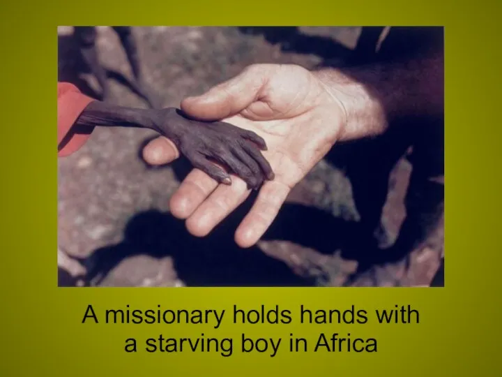 A missionary holds hands with a starving boy in Africa