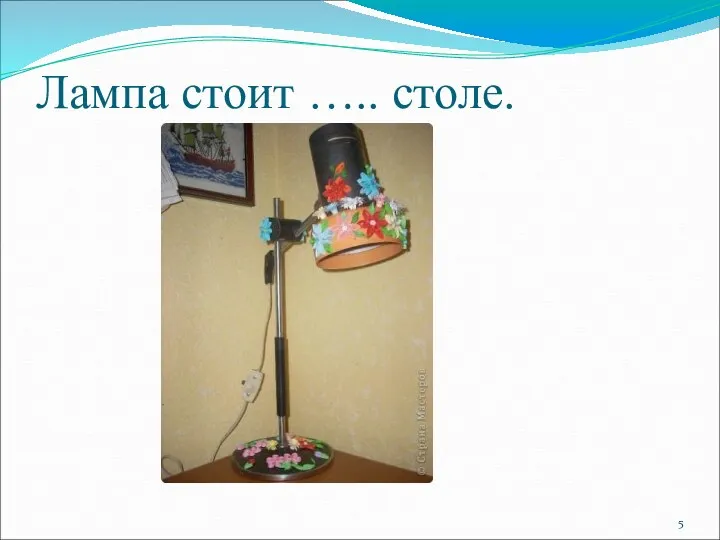 Лампа стоит ….. столе.