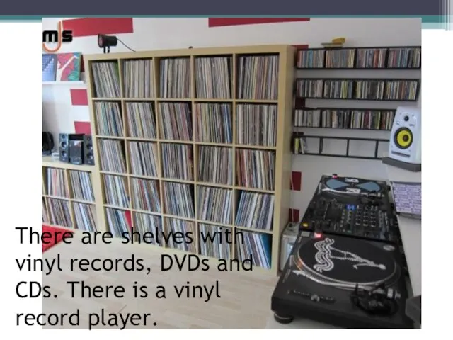 There are shelves with vinyl records, DVDs and CDs. There is a vinyl record player.