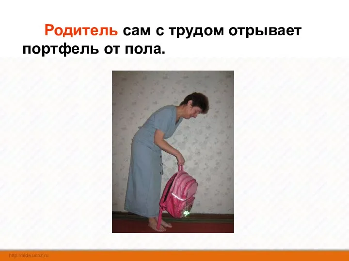 Родитель сам с трудом отрывает портфель от пола.