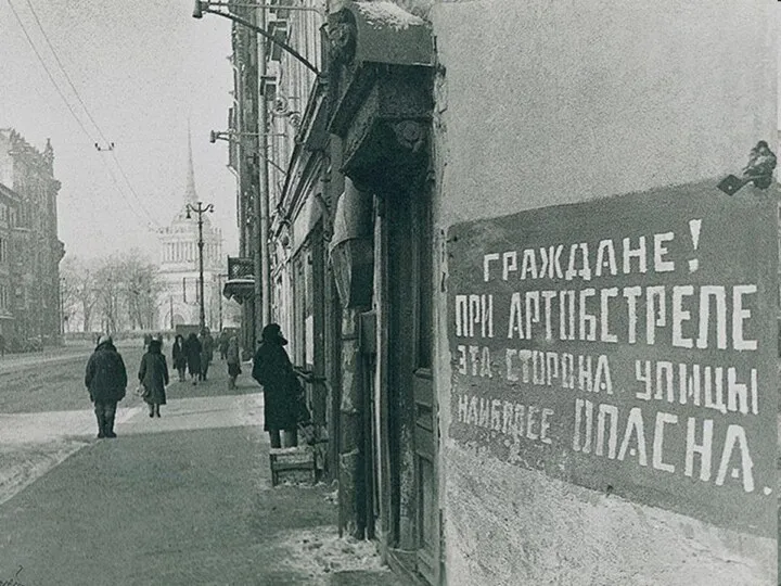 Разрушенные здания И надпись на стене: «Опасно при обстреле На этой стороне».